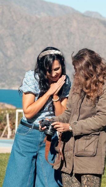 Gaby y una clienta riéndose mientras miran la cámara durante el shooting