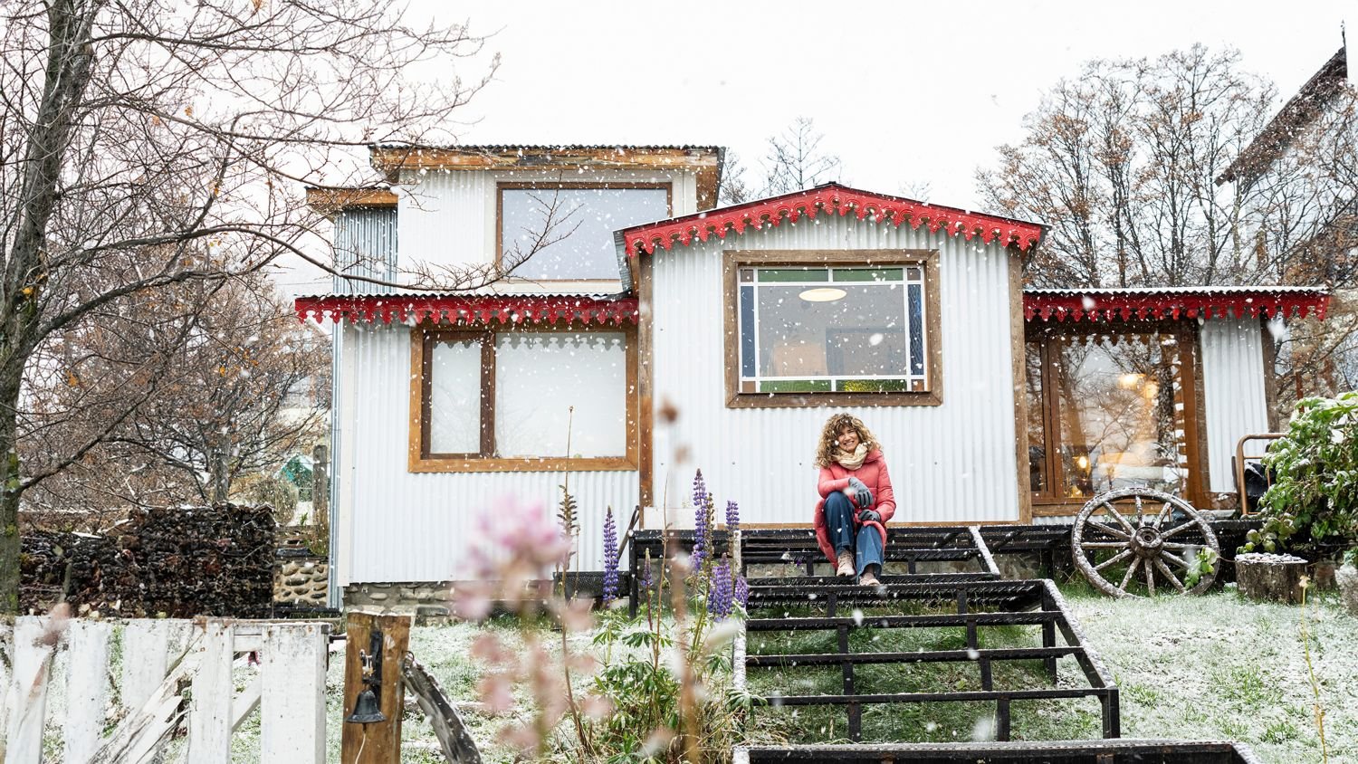 Clienta sentada frente a una casita con nieve en Ushuaia