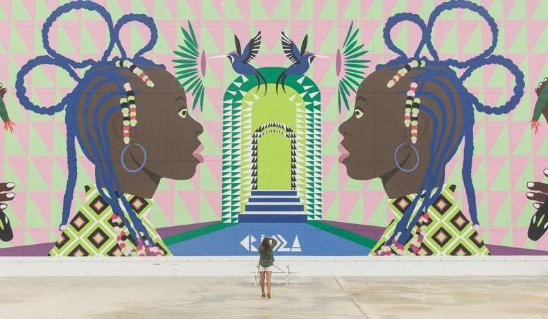 Clienta fotografiada frente a un mural colorido