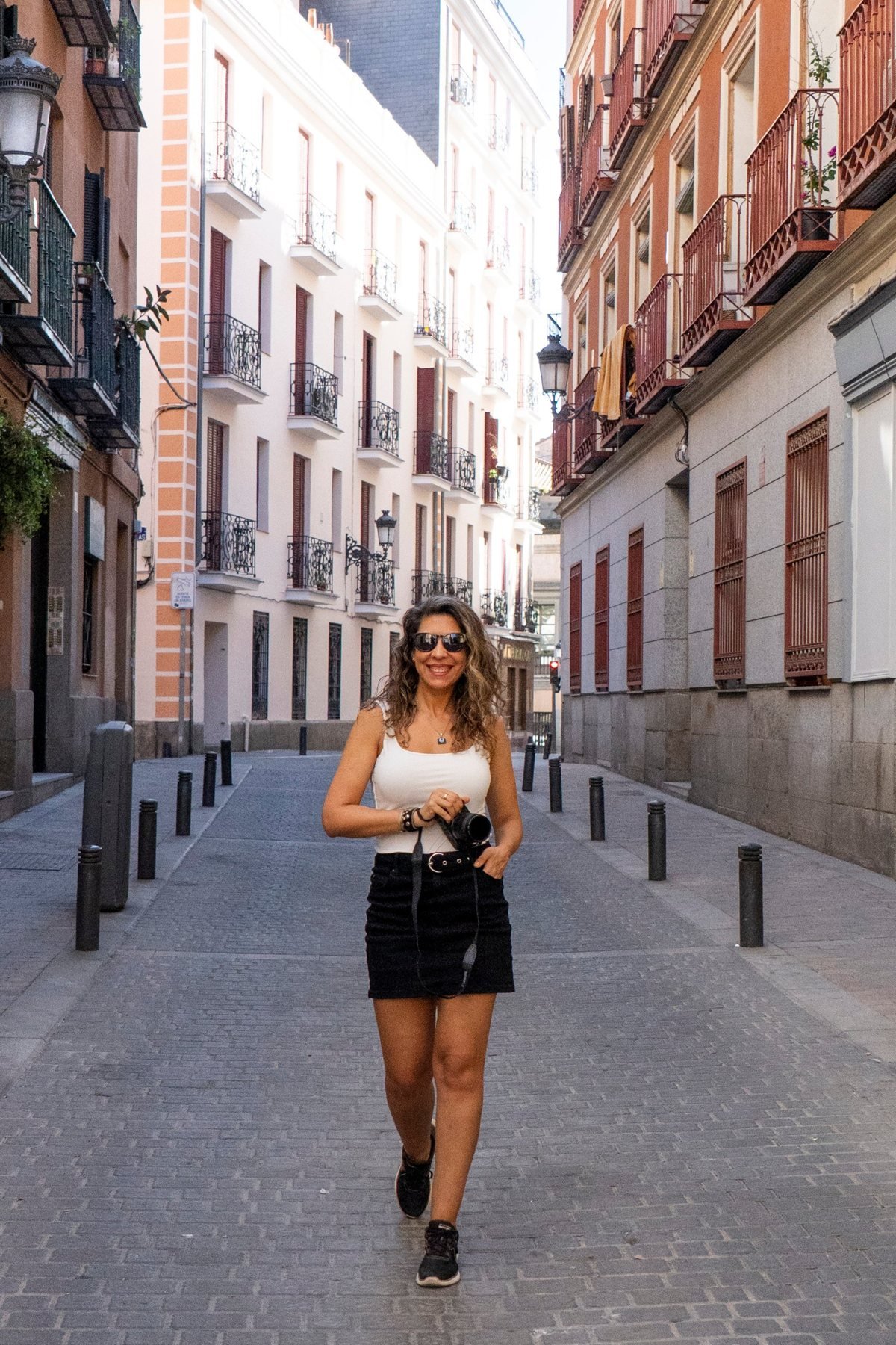 Gaby Caresani sonriendo con su cámara en una calle de Madrid