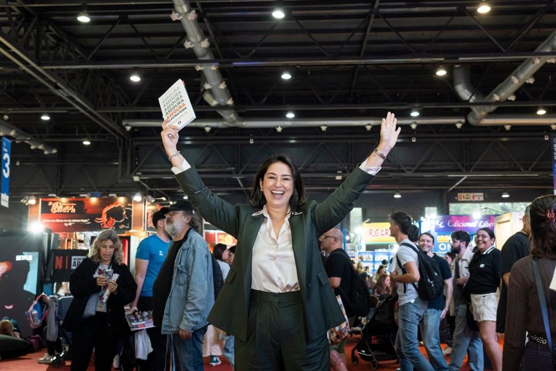 Autora con su libro en alto en la feria