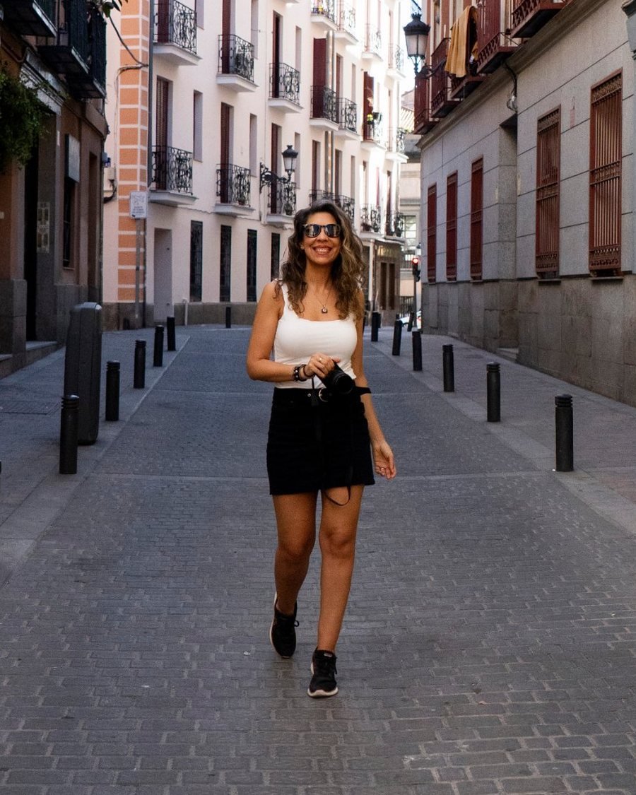Gaby Caresani caminando por una calle de Madrid con su cámara