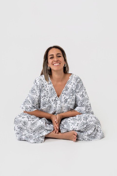Wanda Trotzki sentada en el piso, sonriendo